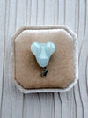 Dreamy Jade elegant pale green carved jade rabbit pendant with a silver-tone bail on a beige velvet jewellery box.