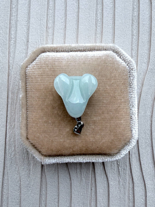 Dreamy Jade elegant pale green carved jade rabbit pendant with a silver-tone bail on a beige velvet jewellery box.
