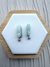 Dreamy Jade rabbit pendants in translucent green jade with rose gold and silver pavé-set stone bails on a display