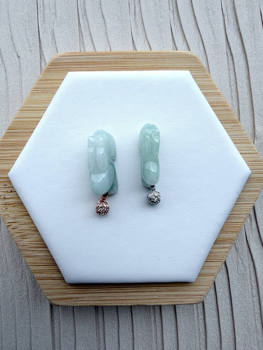Dreamy Jade rabbit pendants in translucent green jade with rose gold and silver pavé-set stone bails on a display