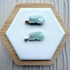 Dreamy Jade rabbit pendants in translucent green jade with rose gold and silver pavé-set stone bails on a display