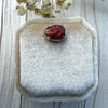 Dreamy Jade red jadeite pendant with intricate hand-carved swirling motifs set in a silver-tone frame with crystal.