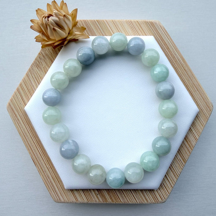 Dreamy Jade round bead bracelet featuring polished natural jadeite in soft mint green and lavender hues on a display.