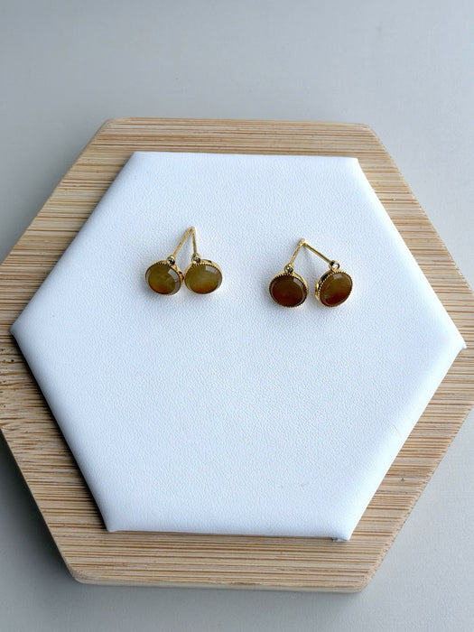 Dreamy Jade round stud earrings featuring warm-toned jade stones in gold-tone settings with sparkling accent details.
