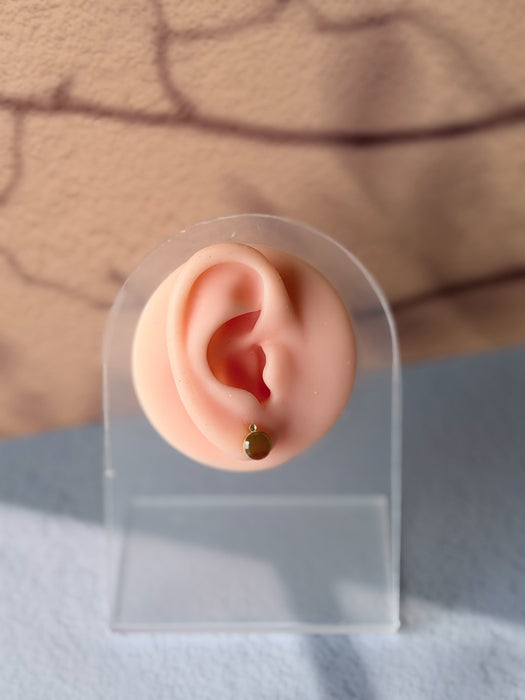 Dreamy Jade round stud earrings featuring warm-toned jade stones in gold-tone settings on a display ear model.