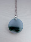 Dreamy Jade round pendant necklace featuring a green patterned jade disc on a silver chain with a floral bail