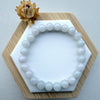 Dreamy Jade white natural jade bead bracelet with smooth polished finish on a hexagonal display stand